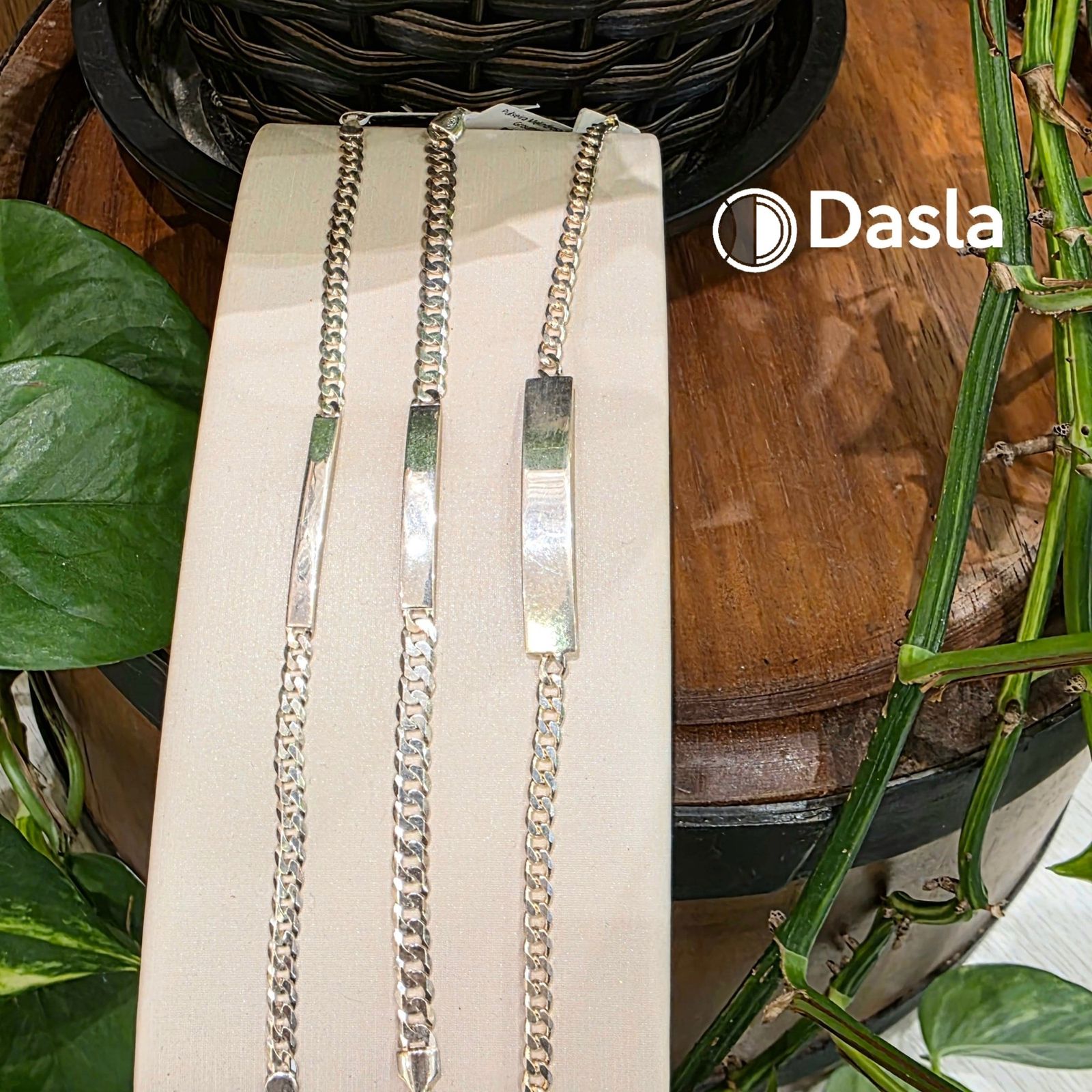 Três pulseiras de prata com placa lisa sobre um suporte claro